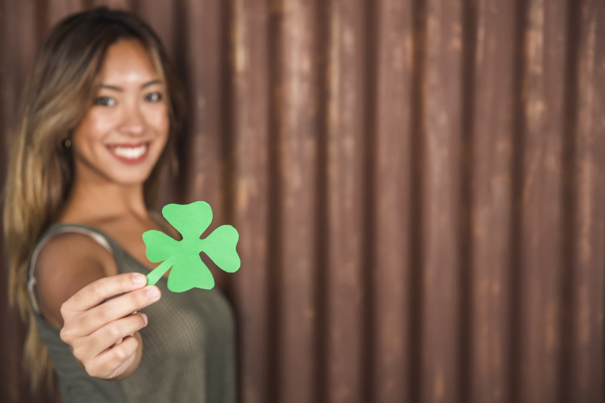happy-woman-holding-green-paper-clover